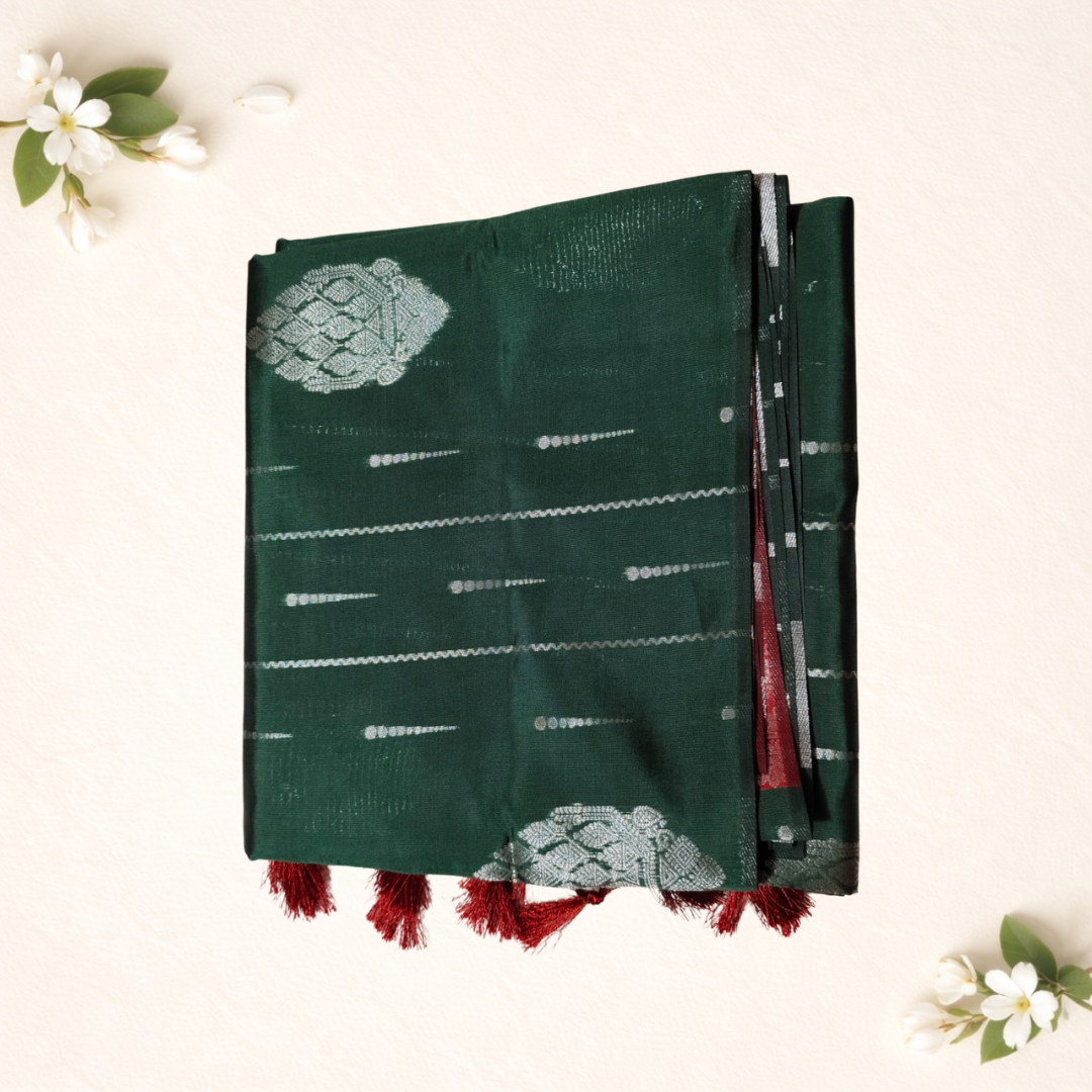 Green fabric with white patterns and red tassels on a light background